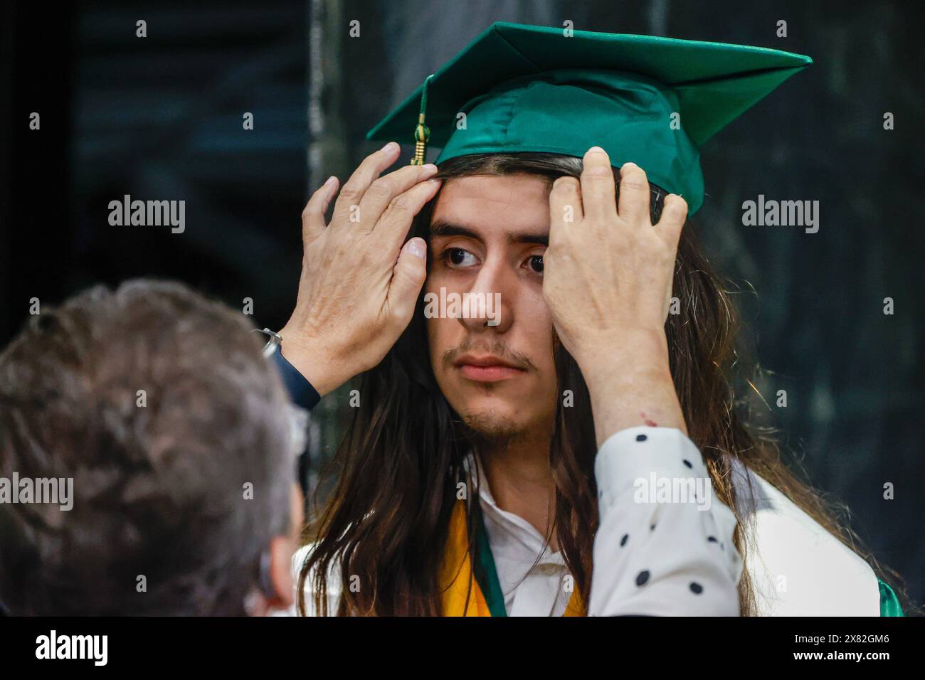 Tampa, Florida, USA. 22nd May, 2024. English teacher Desiree Addison helps graduate Sam Rico-Orta, 18, get ready before he walks the stage during Chamberlain High School's graduation ceremony at the Florida State Fairgrounds Expo Hall on Wednesday, May 22, 2024, in Tampa. (Credit Image: © Jefferee Woo/Tampa Bay Times via ZUMA Press Wire) EDITORIAL USAGE ONLY! Not for Commercial USAGE! Stock Photo