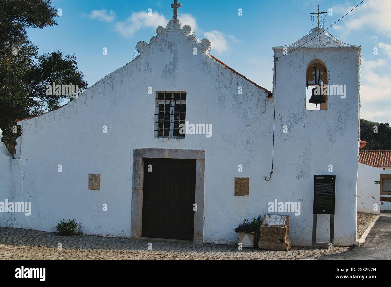 The 18th-century village church of Bordeira, Algarve, Portugal, with whitewashed walls and a small clocktower Stock Photo