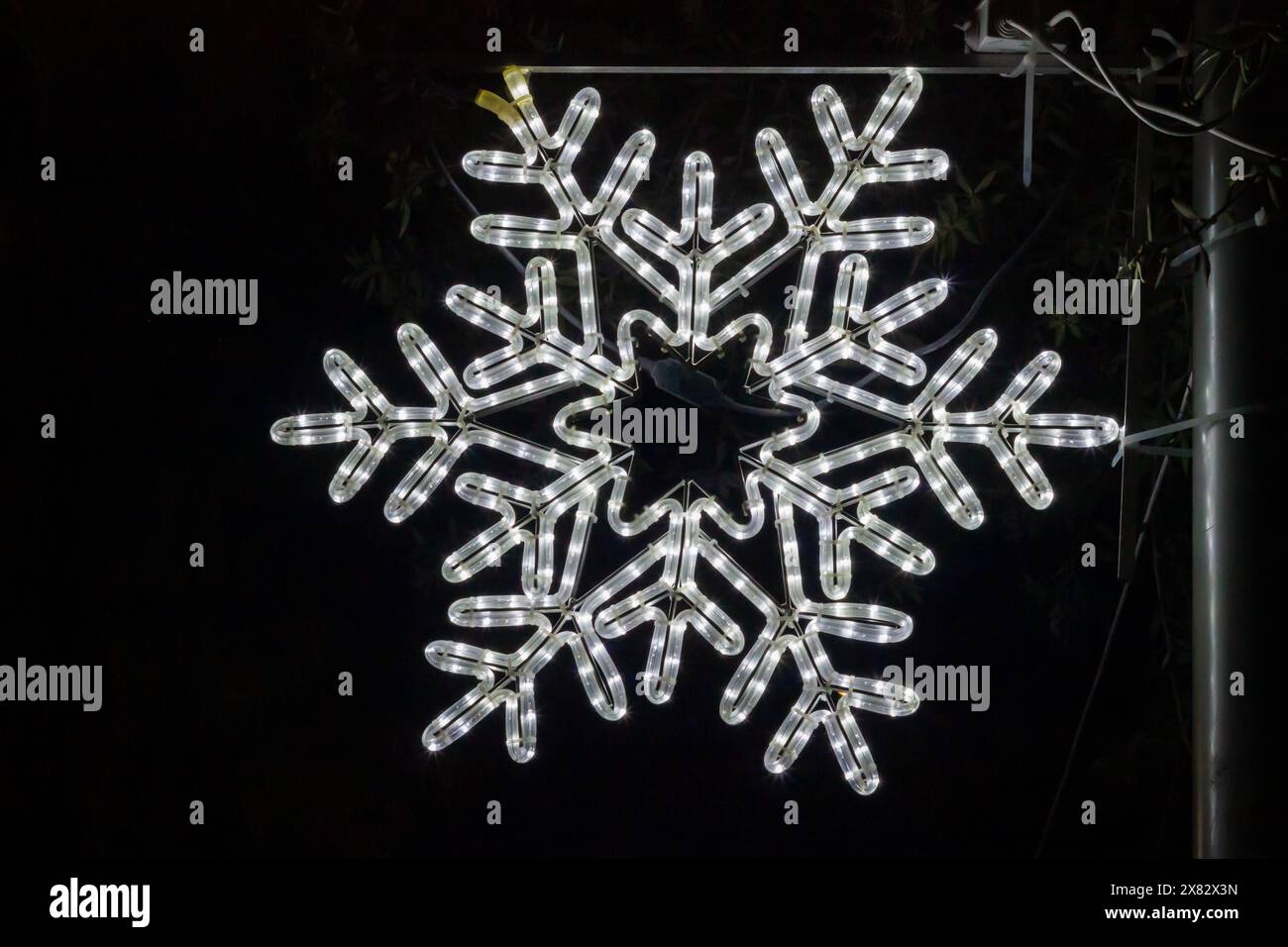 Shiny snowflake on black background with abstract pattern Stock Photo