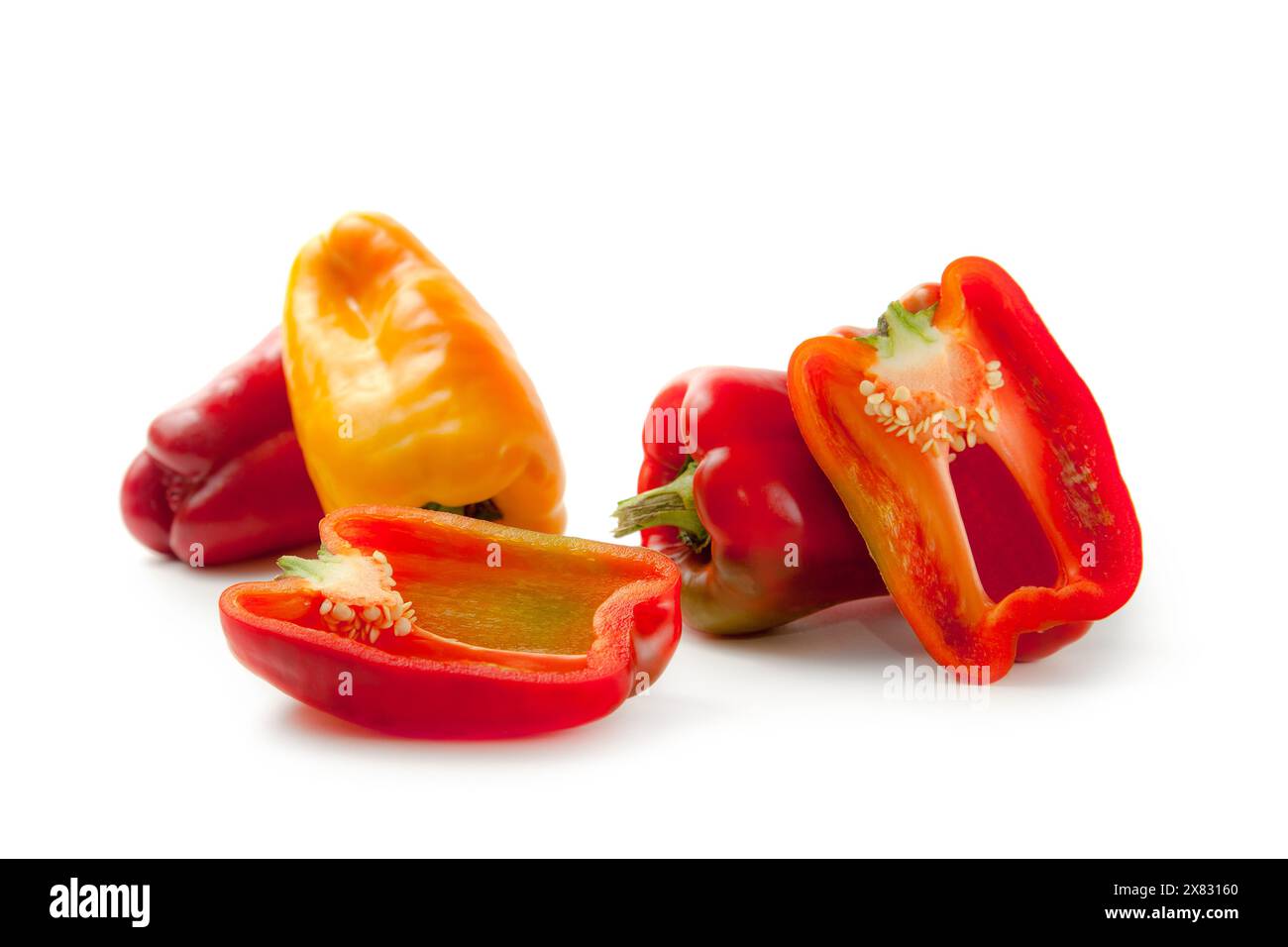 Whole and halves of red and yellow bell pepper (capsicum) known as ...