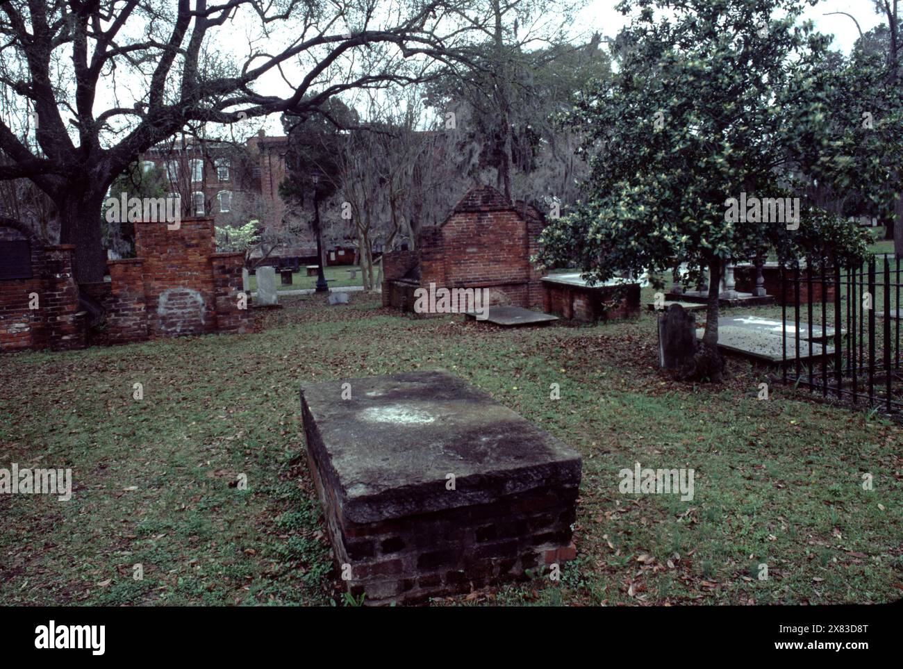 Savannah, GA., USA. 1983. Colonial Park Cemetery is a colonial America cemetery in downtown Savannah, Georgia.  A city park in 1896. The cemetery was established in 1750, when Savannah was the capital of the British Province of Georgia, last of the Thirteen Colonies.  Button Gwinnett (1735–1777), a signer of the Declaration of Independence monument speaks to Colonial Park Cemetery’s Colonial America history! Stock Photo
