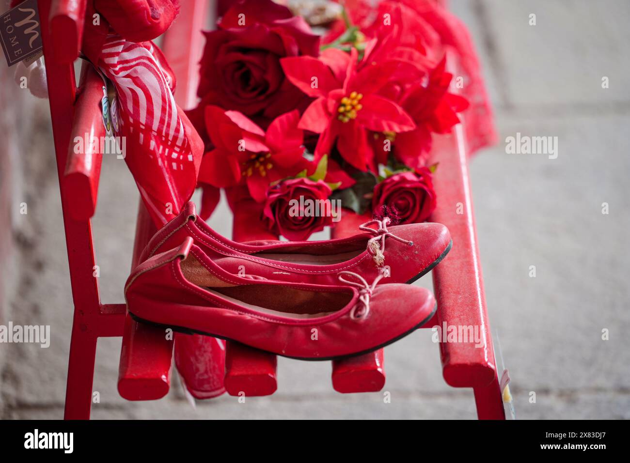 Red shoes on bench against violence against women Stock Photo