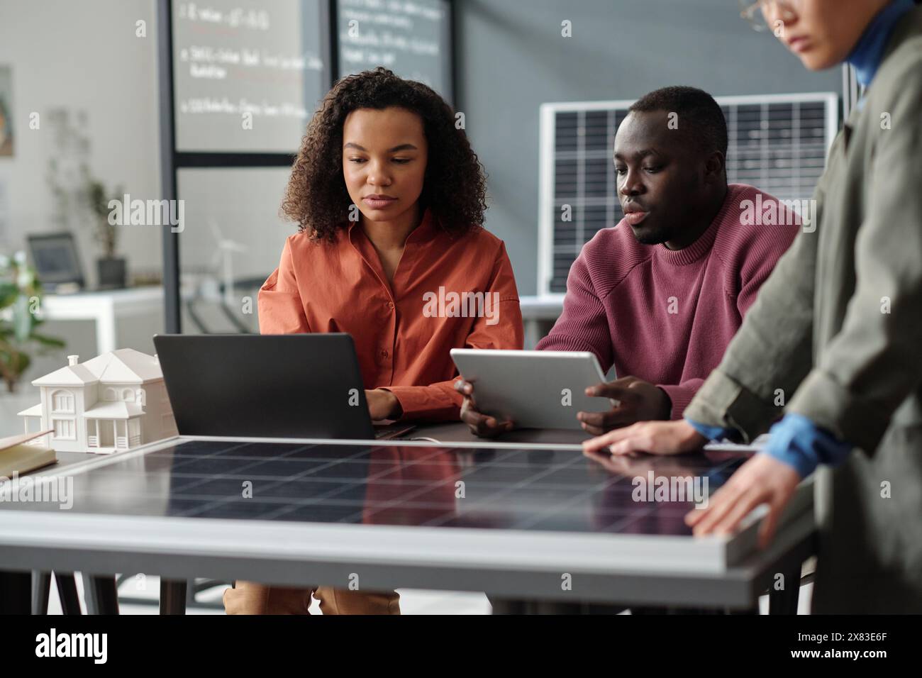 Two young African American employees with laptop and tablet preparing ...