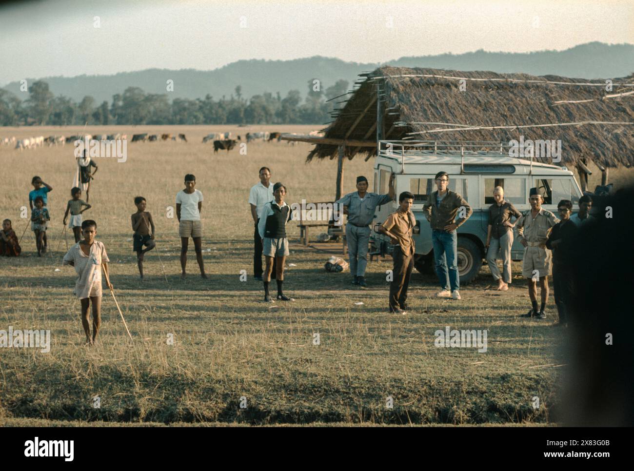 Crowd awaits arrival of DC-3 on dirt airstrip at Pokhara, Nepal in September 1969. Stock Photo