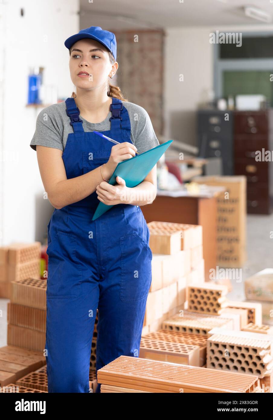 Female foreman making task list in building under construction Stock Photo