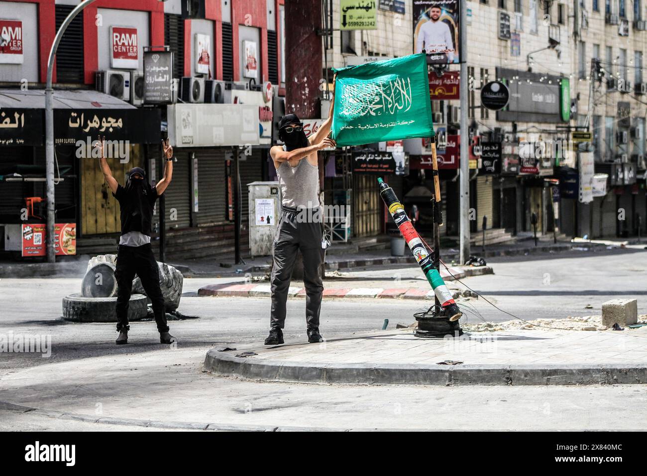 Jenin, West Bank, Palestine. 22nd May, 2024. Palestinian youth holds a flag of the Islamic Resistance Movement Hamas and mock rocket during the clashes with Israeli forces that are raiding the Palestinian Jenin refugee camp for the second day in a row, in the northern West Bank. Eyewitnesses reported that the number of people killed by Israeli gunfire so far is eight, including children and the elderly. (Credit Image: © Nasser Ishtayeh/SOPA Images via ZUMA Press Wire) EDITORIAL USAGE ONLY! Not for Commercial USAGE! Stock Photo
