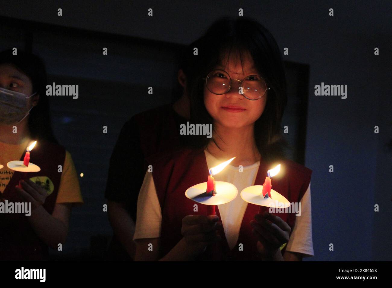 Medan Selayangh, North Sumatra, Indonesia. 22nd May, 2024. One of the women of the Chinese Buddhist congregation celebrates Vesak 2568 BE in Indonesia by taking part in a candle lighting procession at Brobudur Vihara, Medan, North Sumatra (Credit Image: © Kartik Byma/ZUMA Press Wire) EDITORIAL USAGE ONLY! Not for Commercial USAGE! Stock Photo