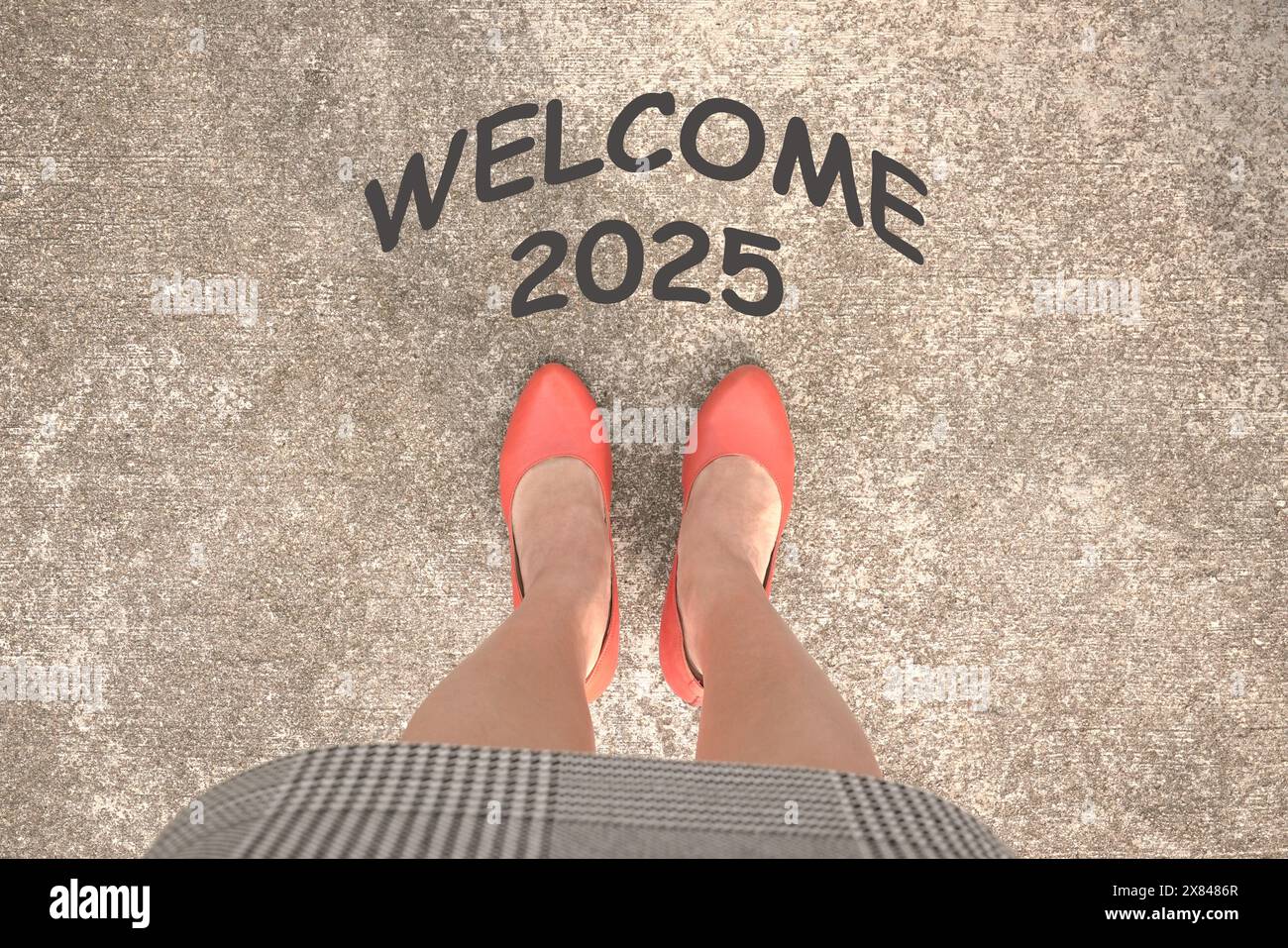 Welcome 2025 on street, in front of a businesswoman. Top view. Stock Photo
