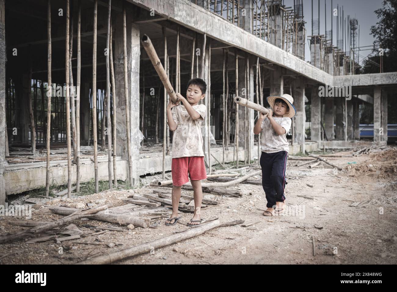 Two poor children are forced to work in construction. Poor children, poverty, Child labor, World Day Against Child Labour concept. Stock Photo