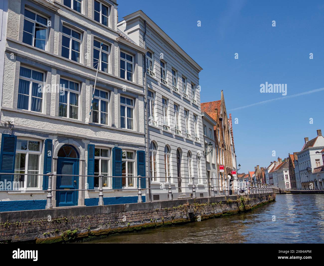 Elegant white buildings and blue windows along a canal in an old city ...
