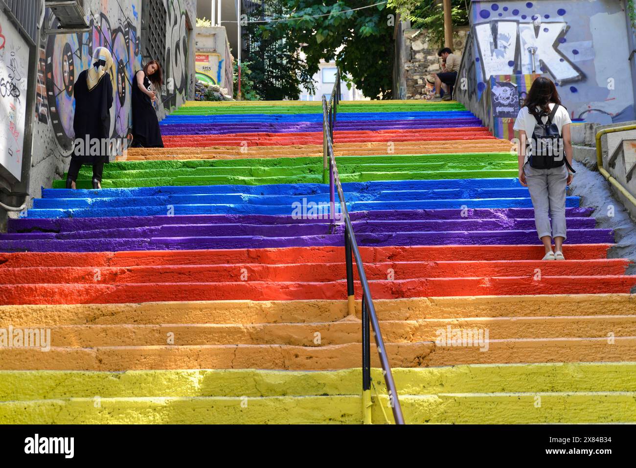 Istanbul, Istanbul Province, Turkey, Asia, A colourful staircase in rainbow colours with people climbing up, surrounded by city streets and graffiti Stock Photo