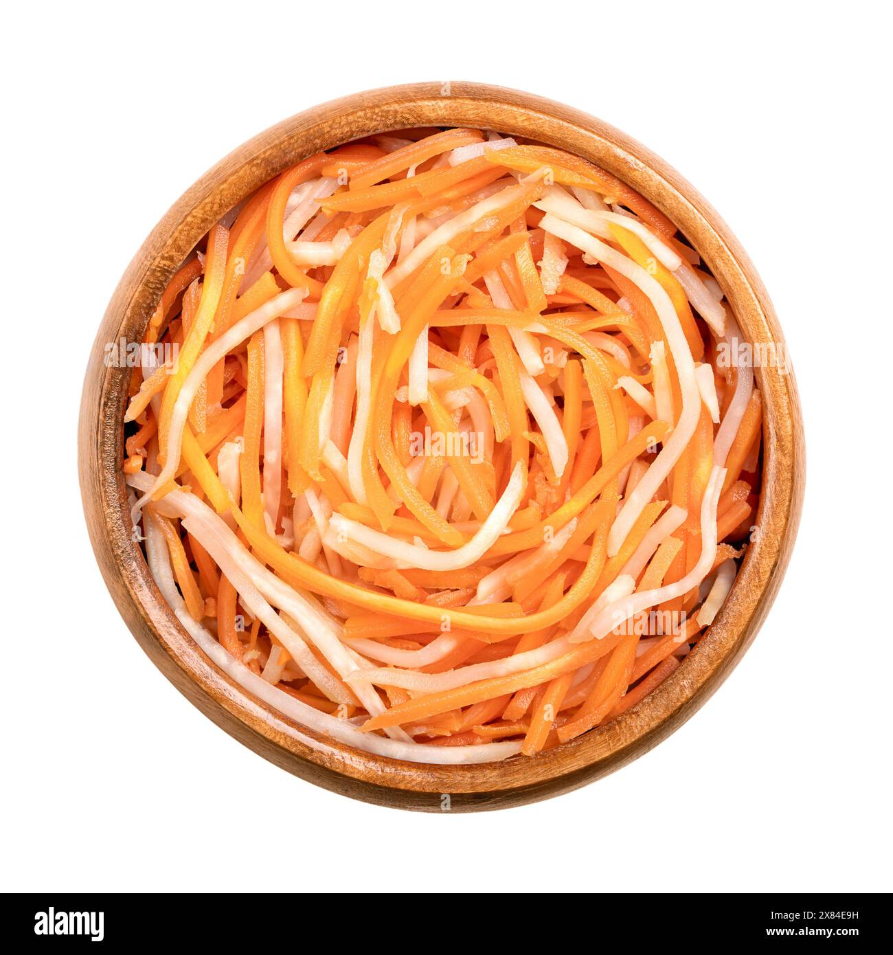 Pickled celeriac and carrot salad in a wooden bowl. Strips of celery root or knob celery, and carrot strips, pasteurized and preserved in brine. Stock Photo