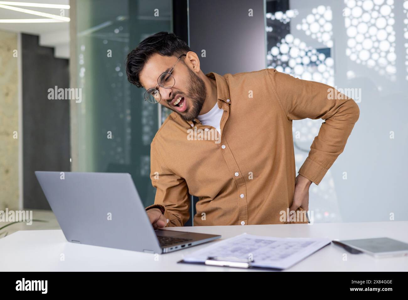 Office worker experiencing back pain and while using laptop