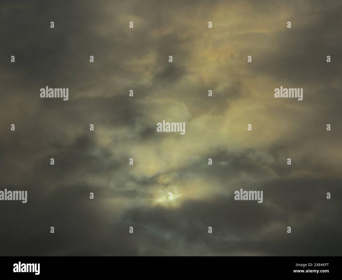 Dark clouds dominate the sky while sunlight breaks through, creating a ...