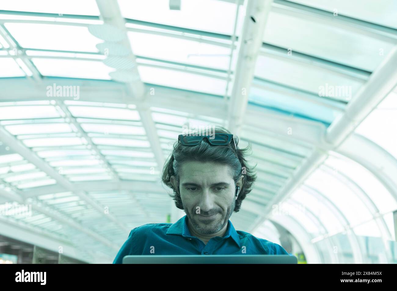 Portrait of one young latin American Caucasian man working on a computer laptop inside and airport. Stock Photo