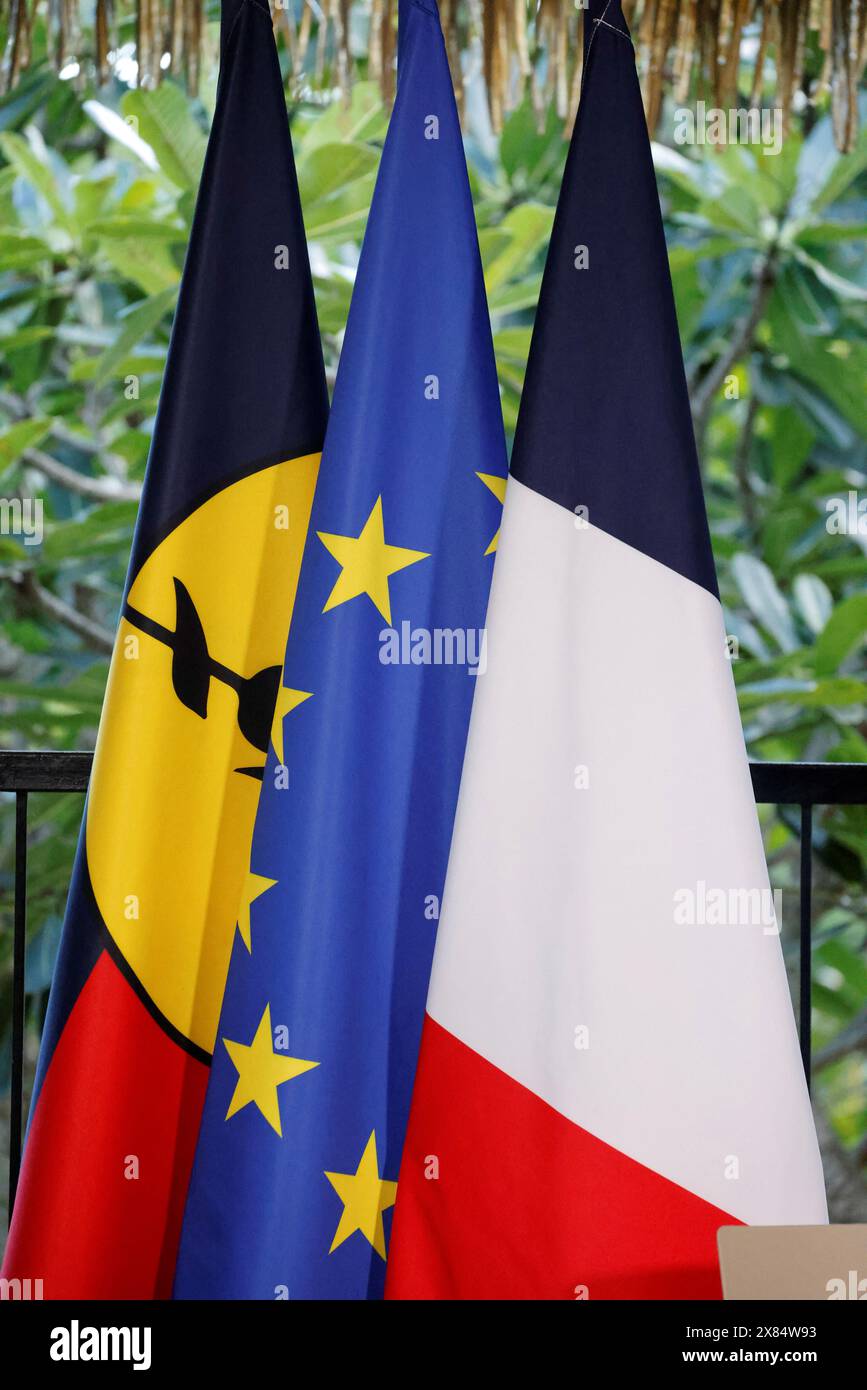 The flags of New Caledonia, the European Union and France are pictured ...