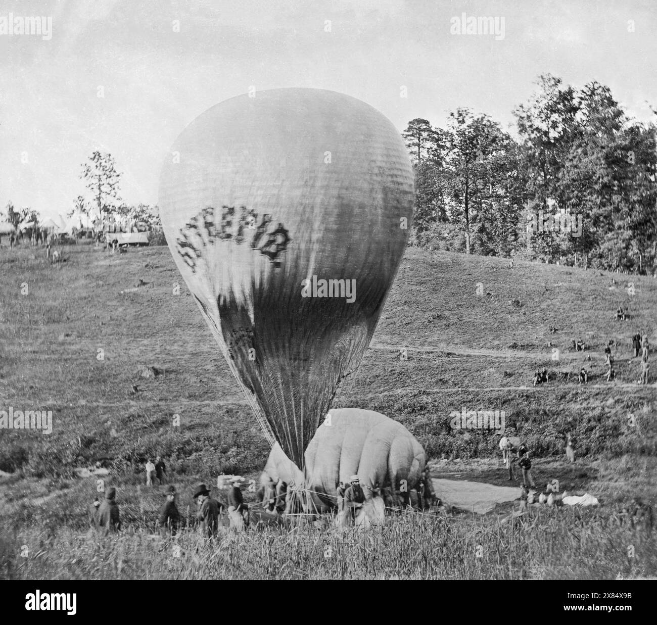 Intrepid being cross-inflated from Constitution, the smaller balloon, in a spur-of-the-moment attempt to get the larger balloon in the air to overlook the imminent Battle of Fair Oaks, May 1862, during the American Civil War. The balloon Intrepid, one of six to eventually be constructed by Thaddeus Lowe and the Union Army Balloon Corps. By Mathew Brady. Please note that this image is a composite of two stereographs. Stock Photo