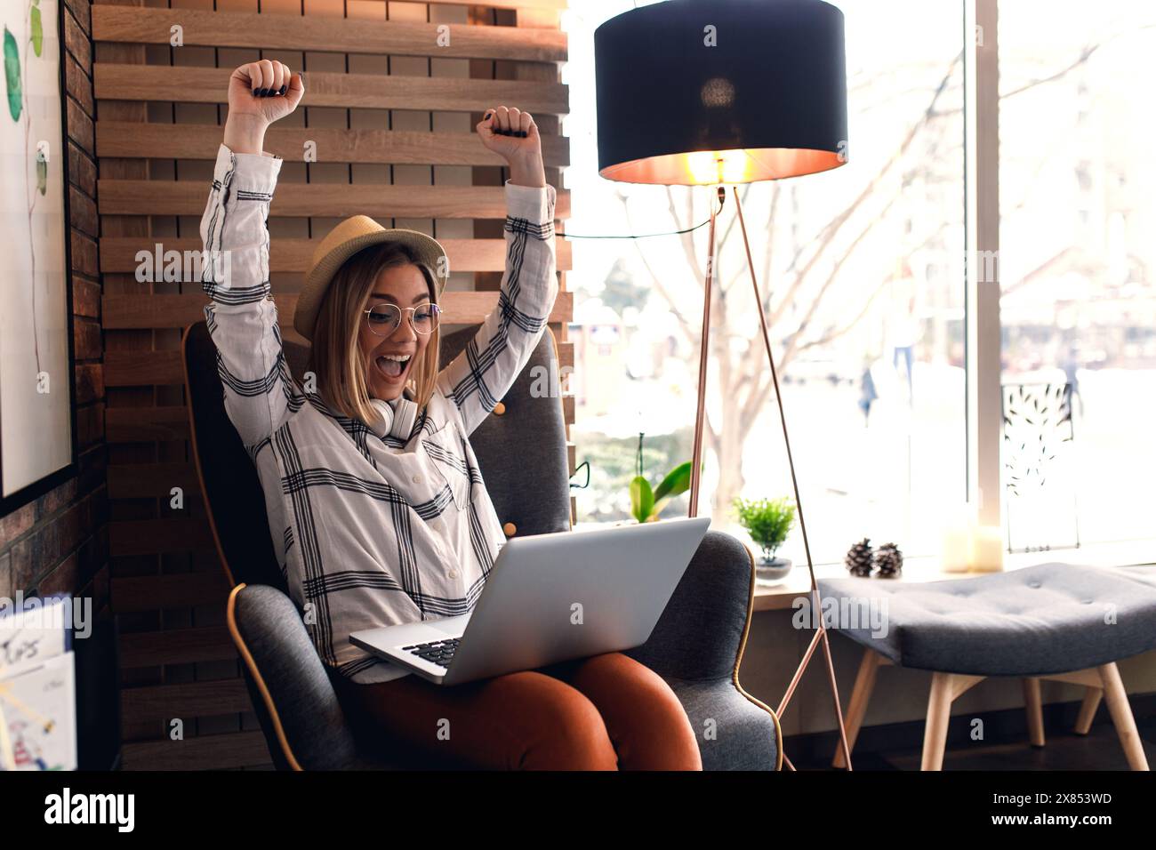 Portrait of young woman working in coffee shop using laptop Stock Photo ...