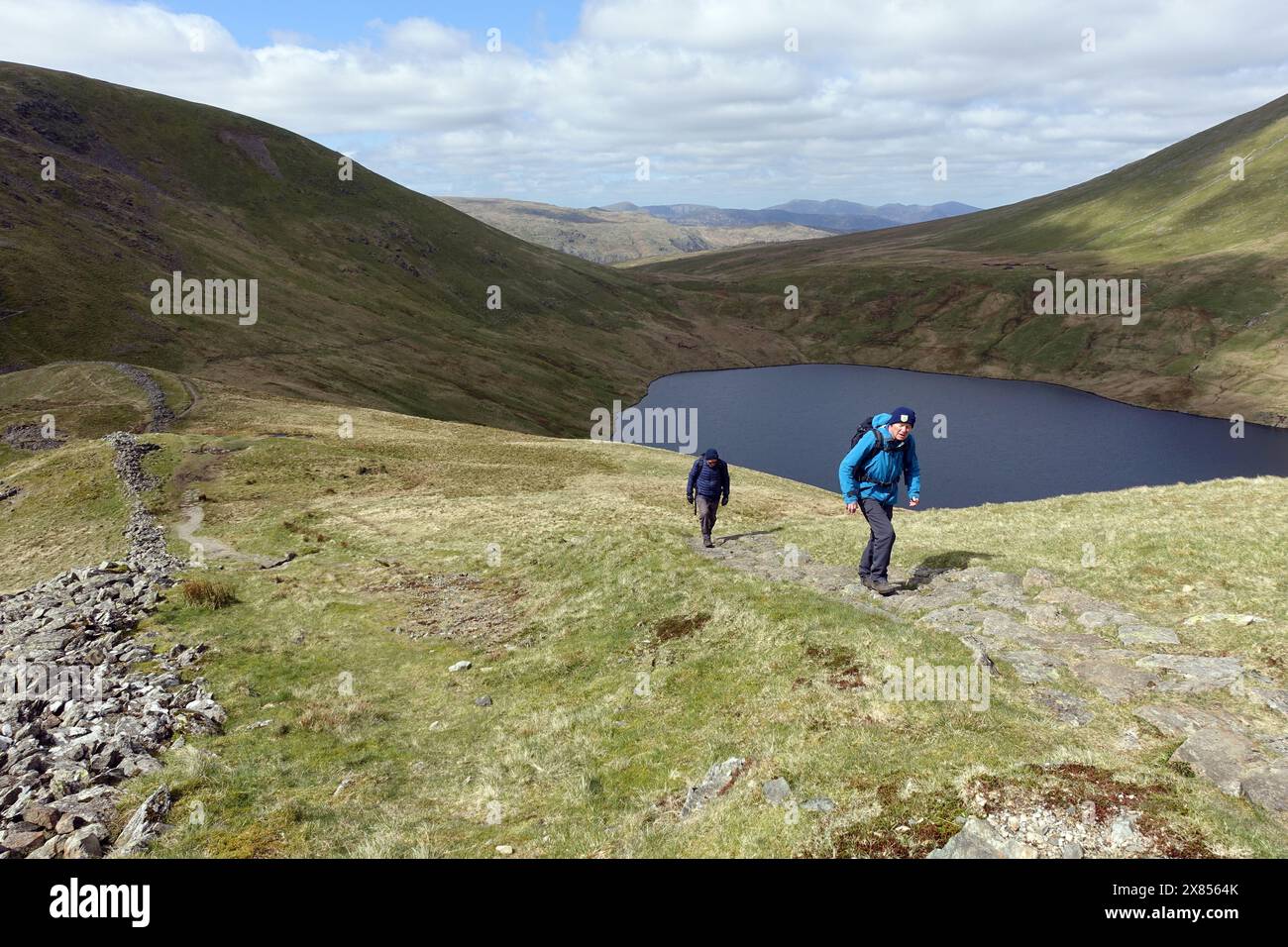 Two Men (Hikers) Walking up the Wainwright 'Fairfield' from Grisedale Hause above Grisedale Tarn in the Lake District National Park, Cumbria, England Stock Photo