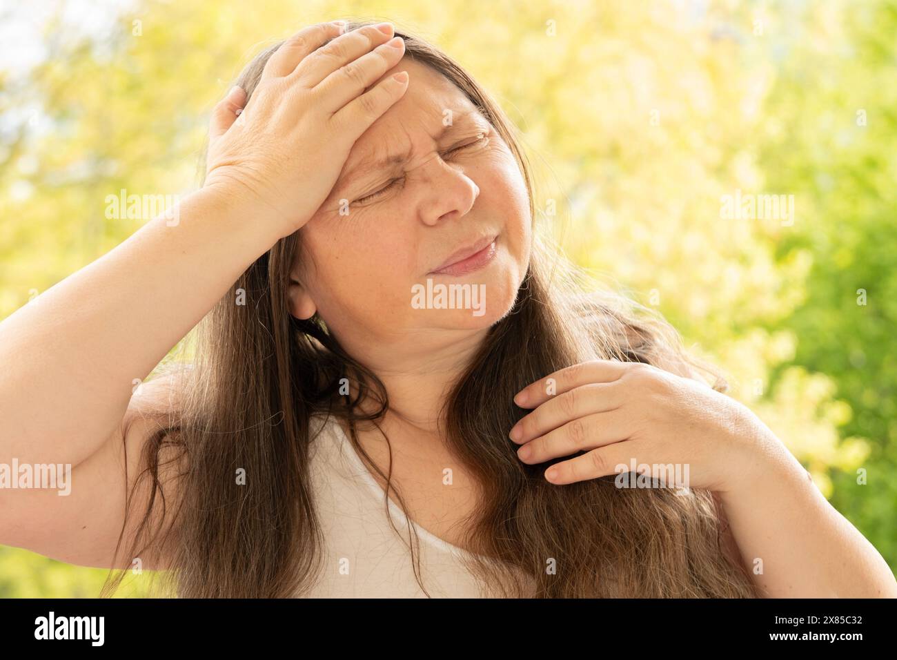 diseased mature woman experiences severe headache, holding head, Hot
