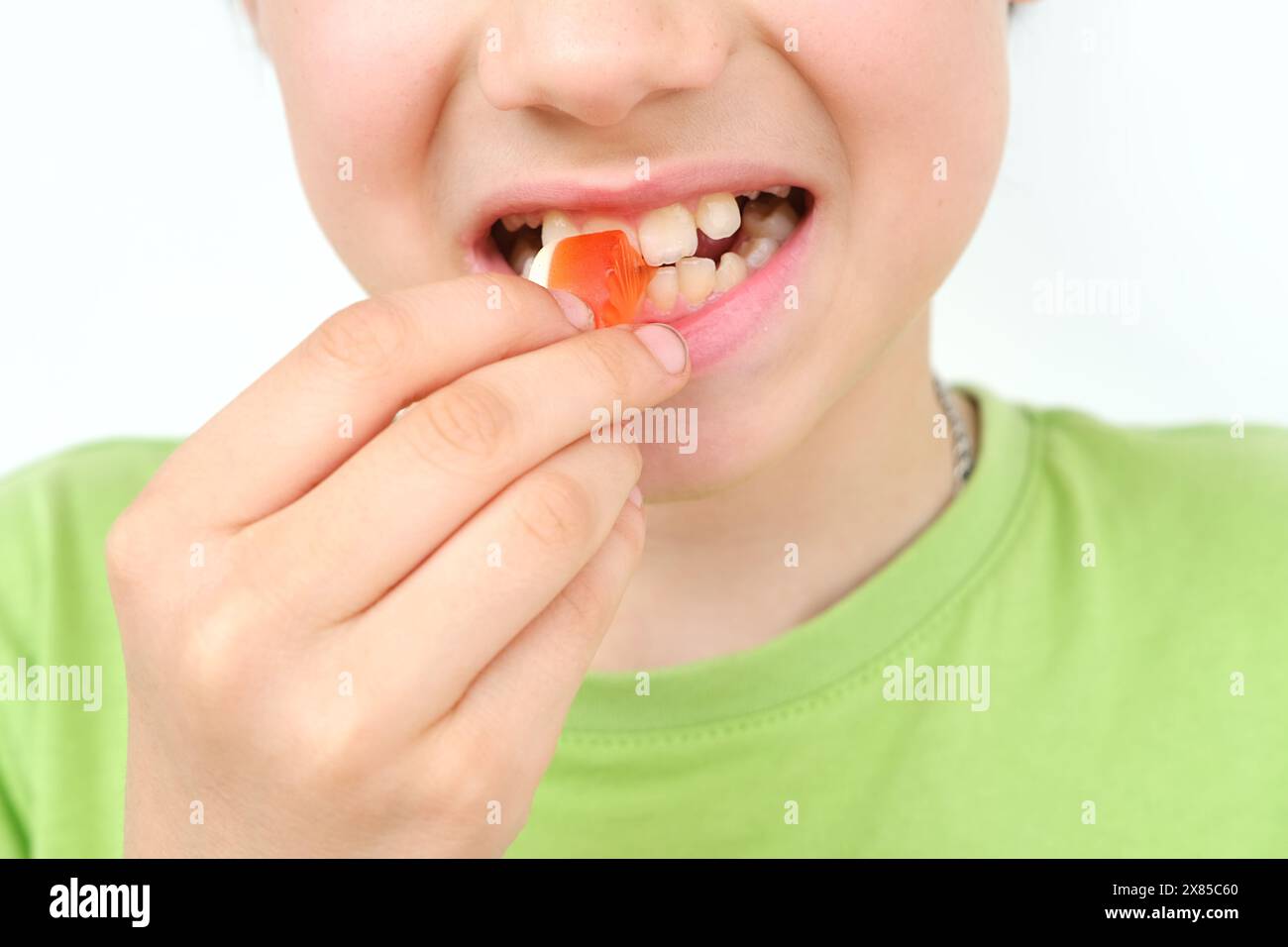 boy, child holds in his mouth and eats gelatinous sweets, gummy sweets, concept of children's delicacy, healthy and unhealthy food, halal food Stock Photo