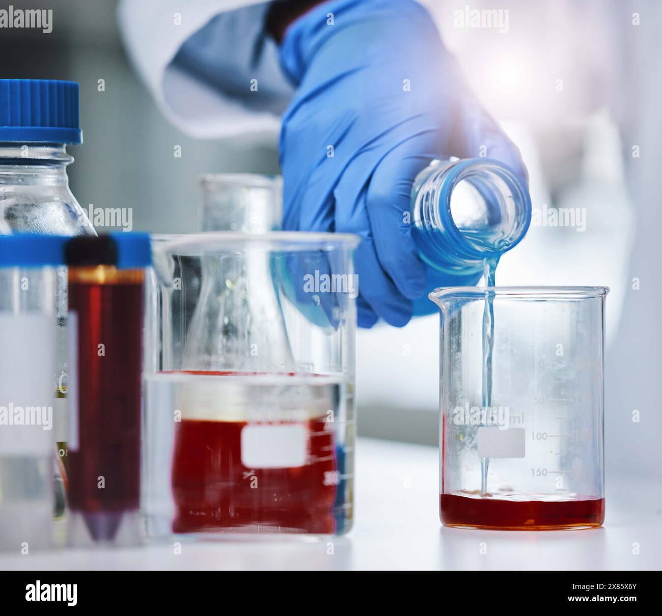 Beaker, blood and hand for research or testing, sample and science for medical data for healthcare. Biotechnology, gloves or specialist for dilution Stock Photo