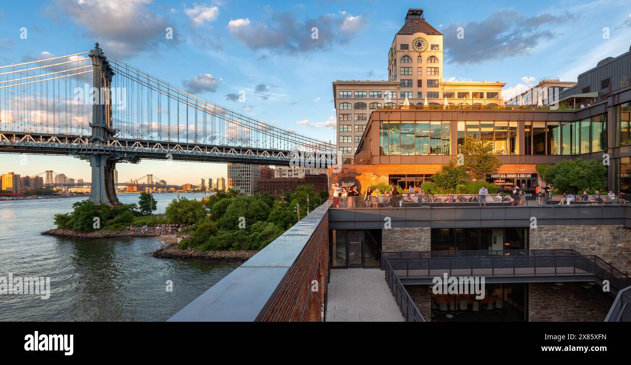 New York City, Brooklyn, DUMBO: People shopping and enjoying the last rays of the sunset at the Empire Stores shopping mall. Empire Fulton Ferry Park Stock Photo