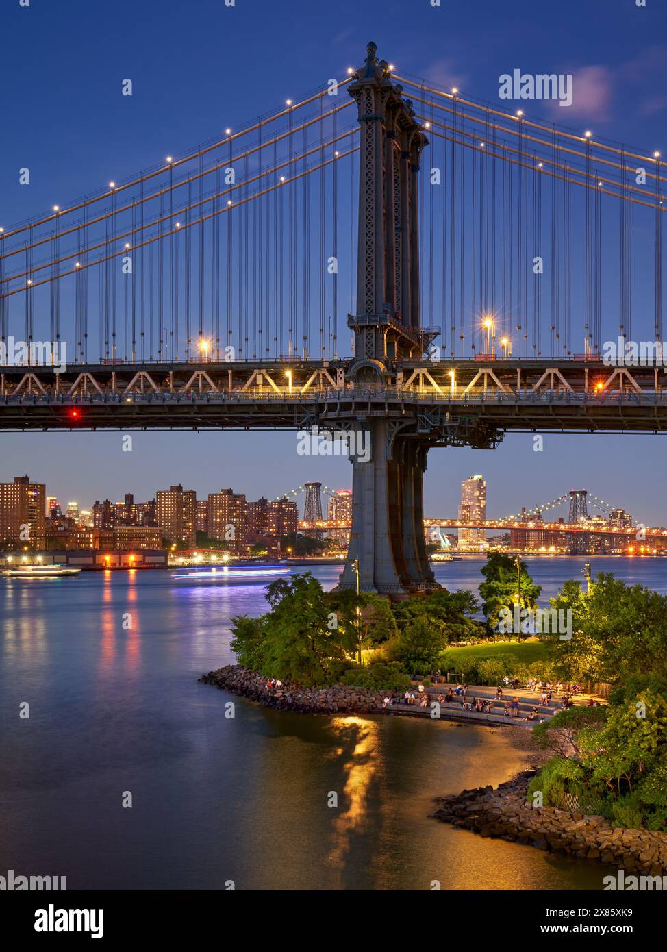 DUMBO, Brooklyn: People enjoying Main Street Park and Peble Beach in summer evening with view on the iconic Manhattan Bridge Stock Photo