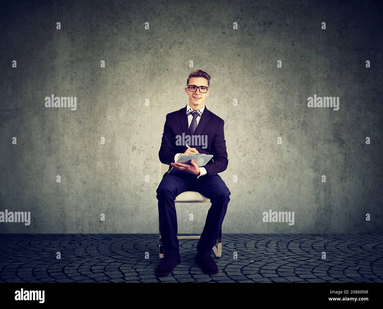 A job applicant young businessman sitting on a chair filling out an