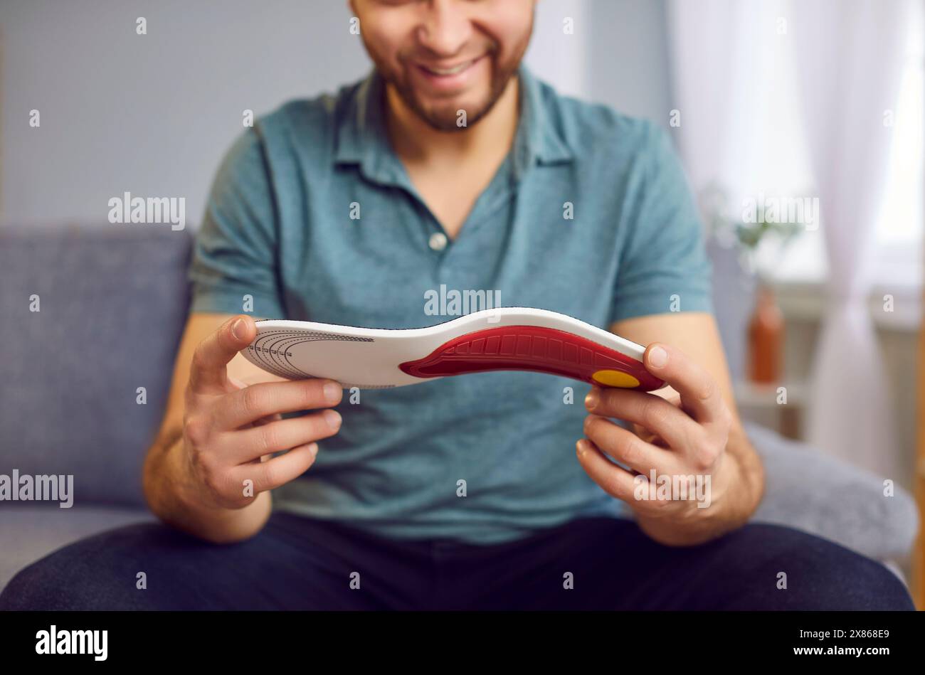 Man Examining Orthopedic Insole At Home Stock Photo