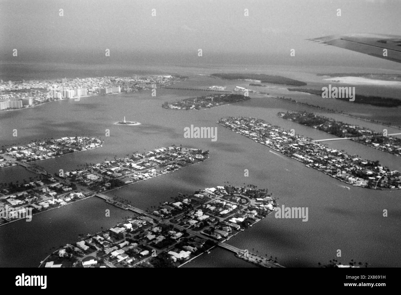 Blick über die Biscayne Bay aus dem Fenster einer Pan Am Machine, im Vordergrund die künstlichen Inseln Rivo Alto, Di Lido und San Marino der Gruppe Venetian Islands links im Hintergrund die Landzunge von Miami Beach, sowie die ebenso künstlichen Inseln Flagler Memorial Island, Star, Palm und Hibiscus Island, sowie Fisher und Dodge Island, Florida 1966. View over Biscayne Bay from the window of a Pan Am Machine, in the foreground the artificial islands Rivo Alto, Di Lido and San Marino of the Venetian Islands group, on the left in the background the headland of Miami Beach, as well as the equa Stock Photo