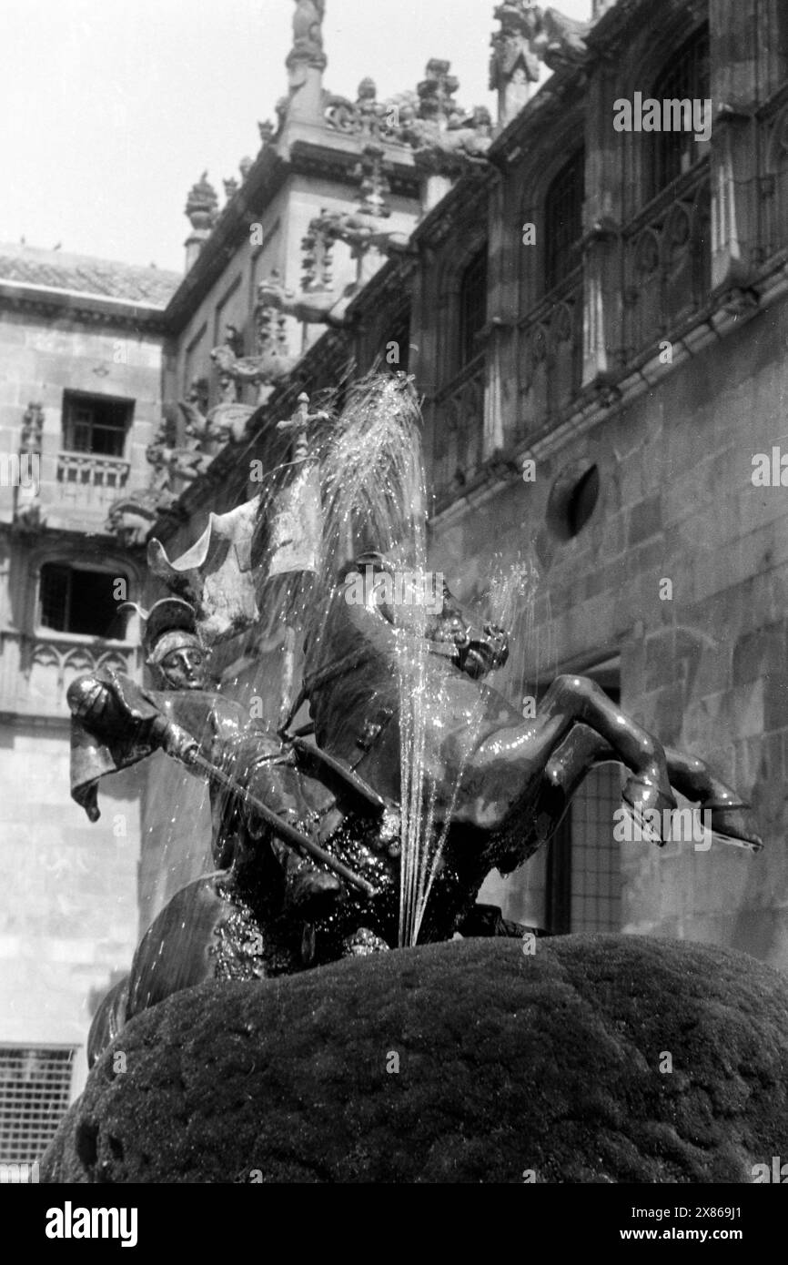 Der Springbrunnen des Heiligen Georg mit dem Lindwurm im Hof der Orangenbäume im Palacio de la Generalitat in Barcelona, Spanien 1957. The fountain of St George with the lindworm in the courtyard of the orange trees in the Palacio de la Generalitat in Barcelona, Spain 1957. Stock Photo