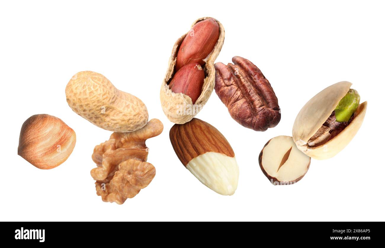 Many different nuts in air on white background Stock Photo