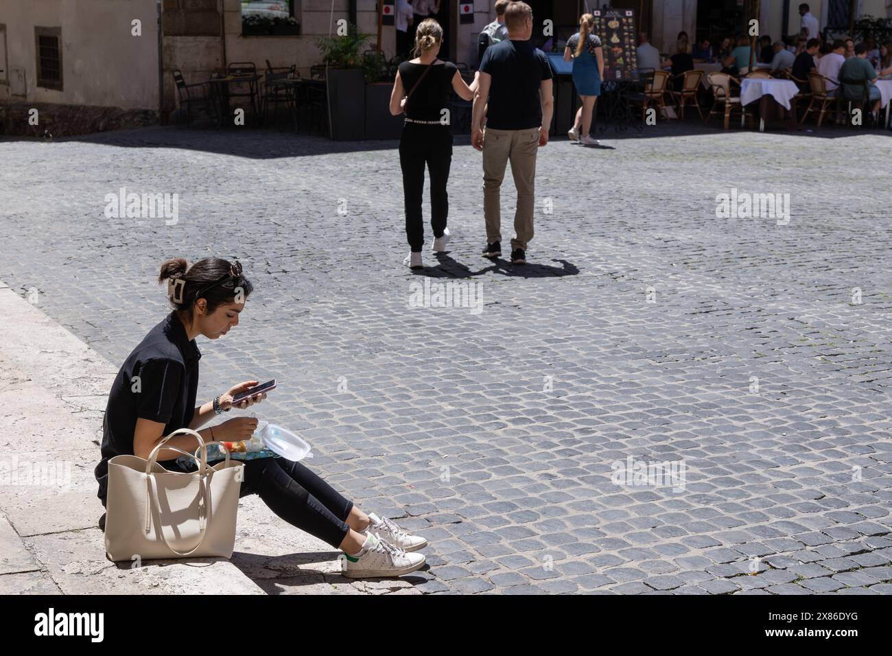 May 23, 2024, Roma, Rm, Italy: A girl eats sitting in a square near Montecitorio Palace in Rome (Credit Image: © Matteo Nardone/Pacific Press via ZUMA Press Wire) EDITORIAL USAGE ONLY! Not for Commercial USAGE! Stock Photo
