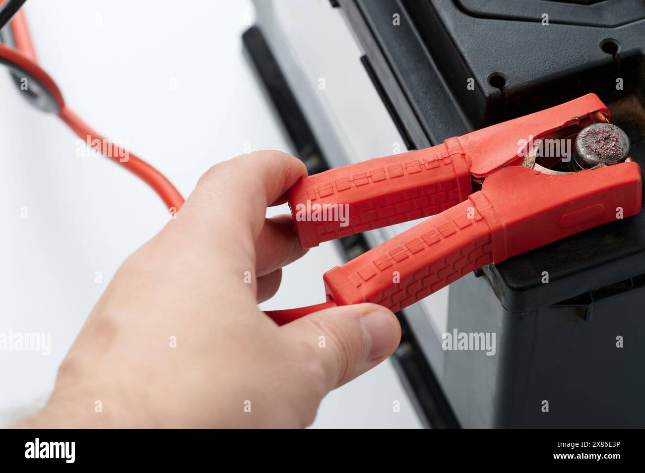 Hand hold battery jumper for charging battery close up view Stock Photo