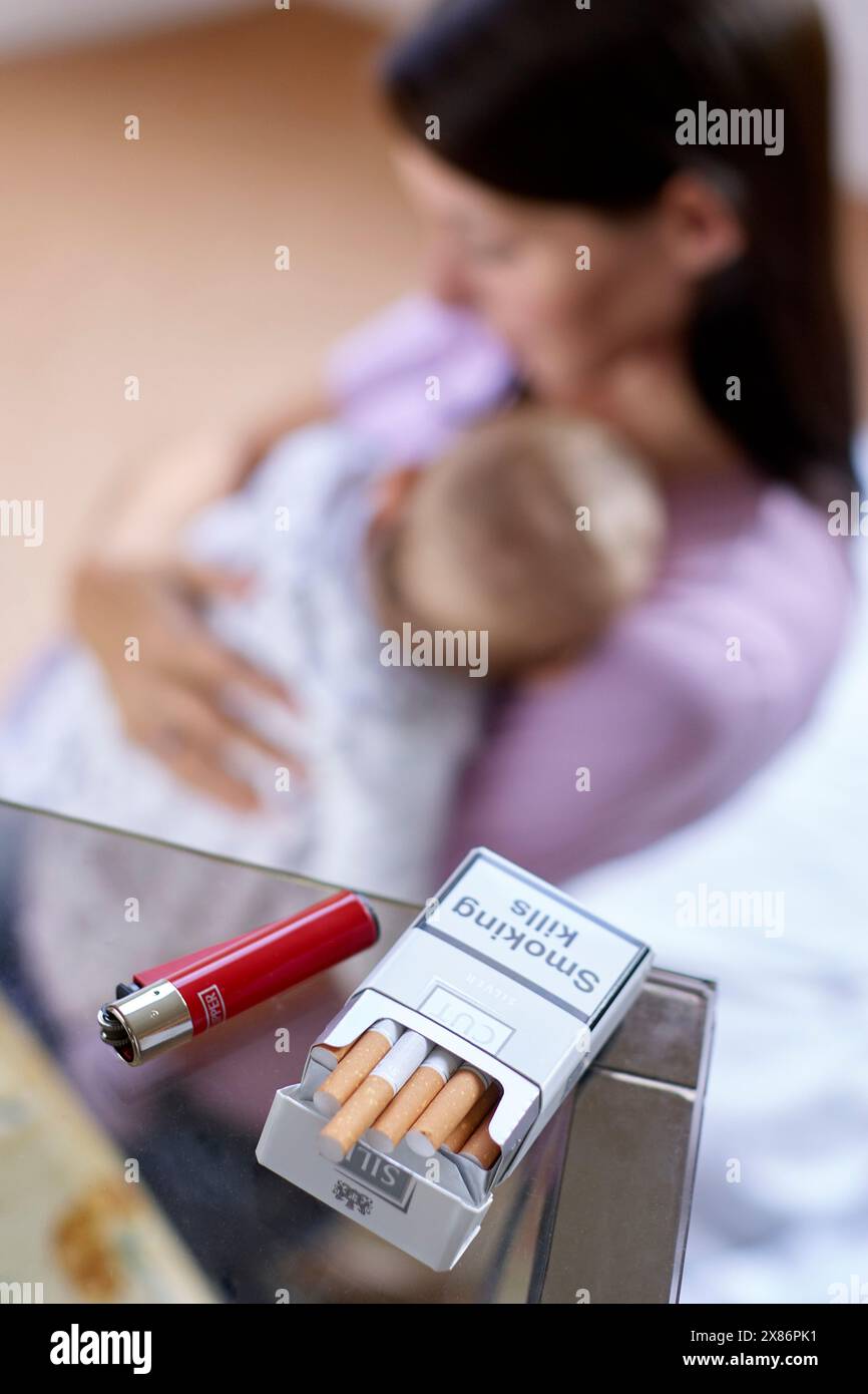 Woman smoking next to newborn baby Stock Photo