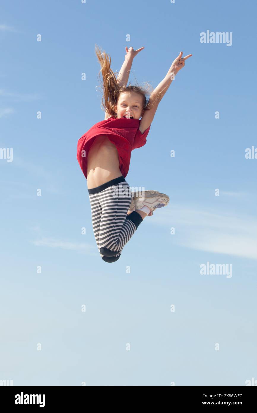 Happy girl jumping blue sky hi-res stock photography and images - Alamy