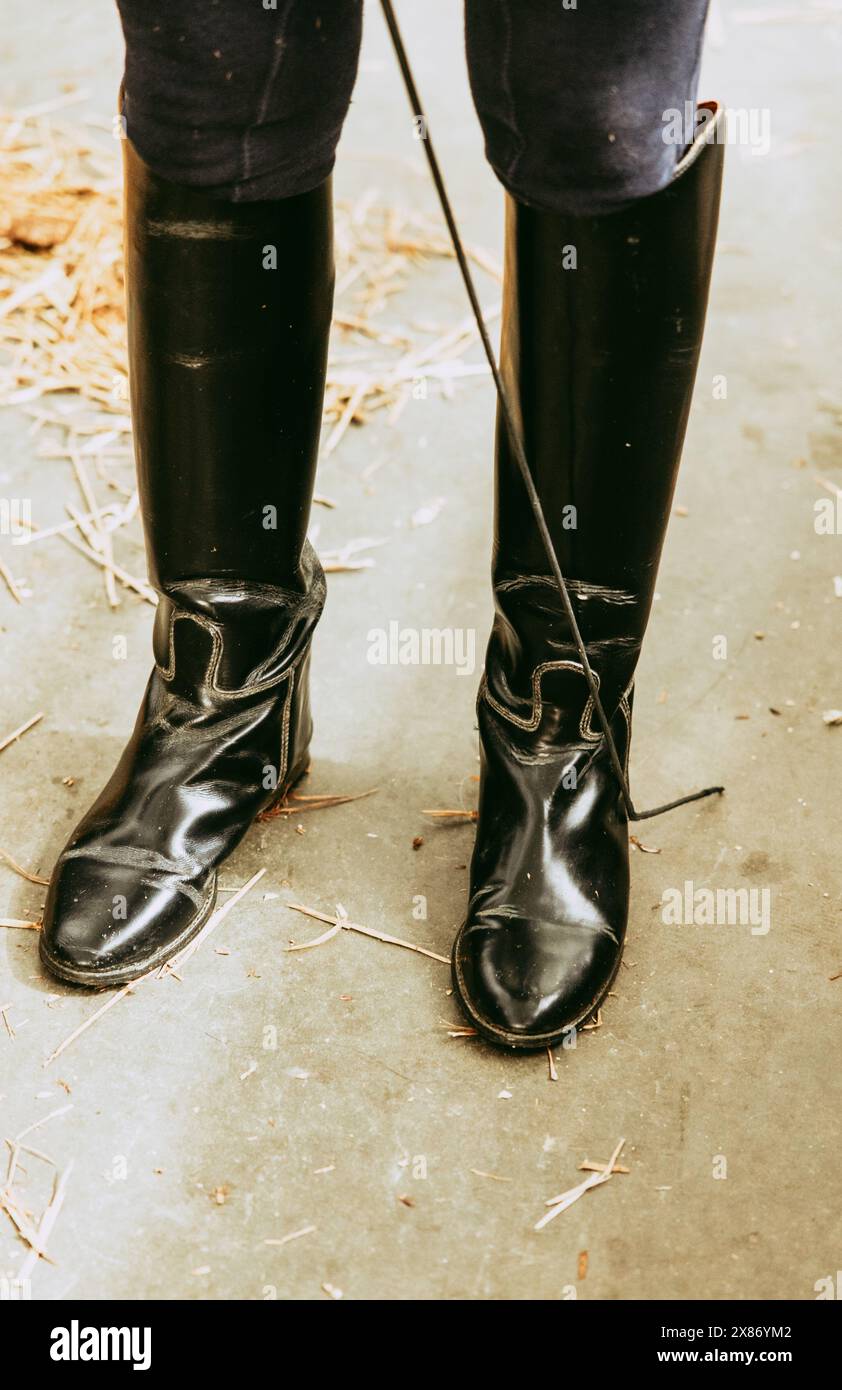 Filling Riding Boots Close-up of a rider's black boots and riding crop in a stable, showing ...
