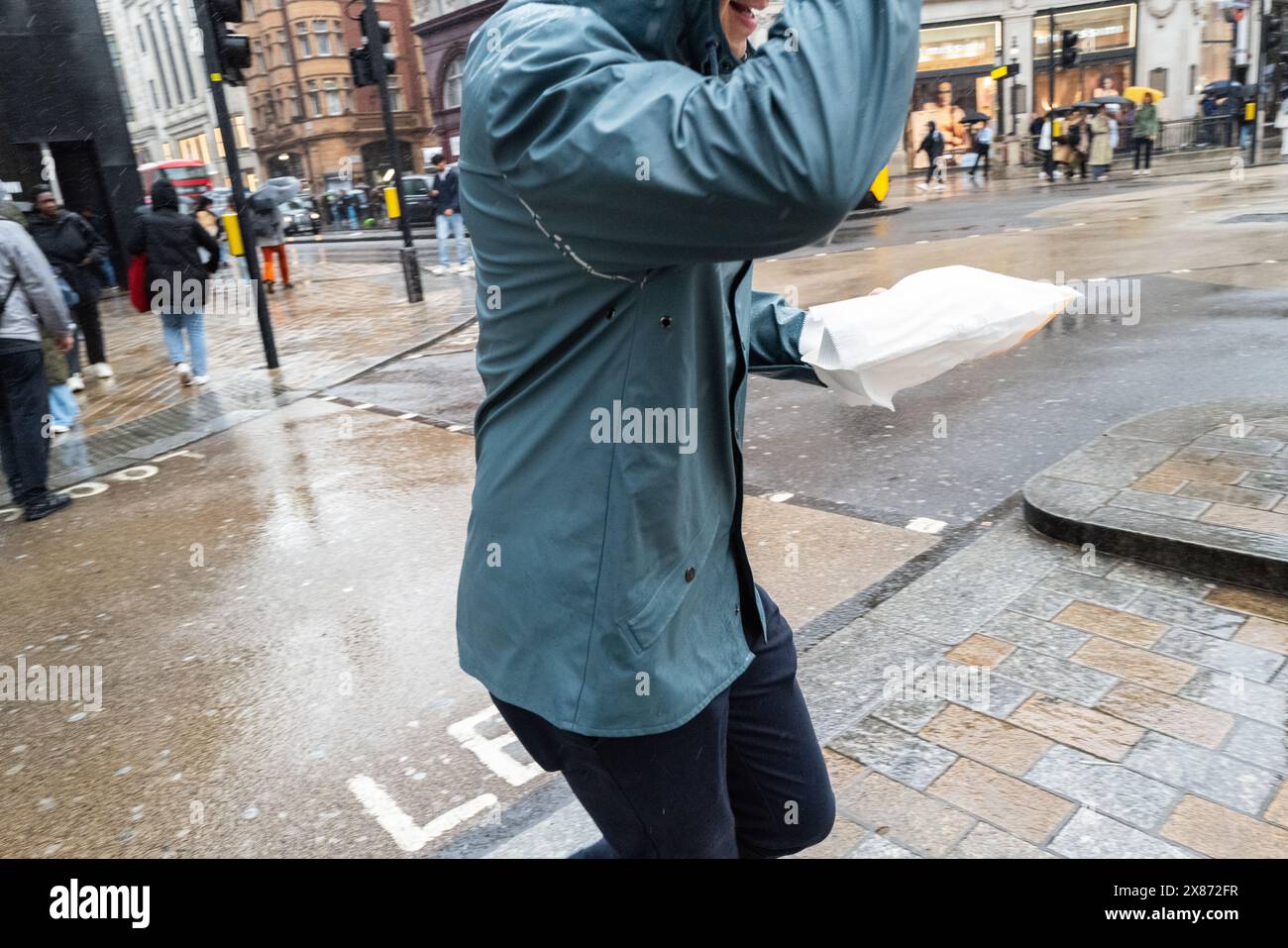 Male with lunch in his hand runs across a London street, UK Stock Photo