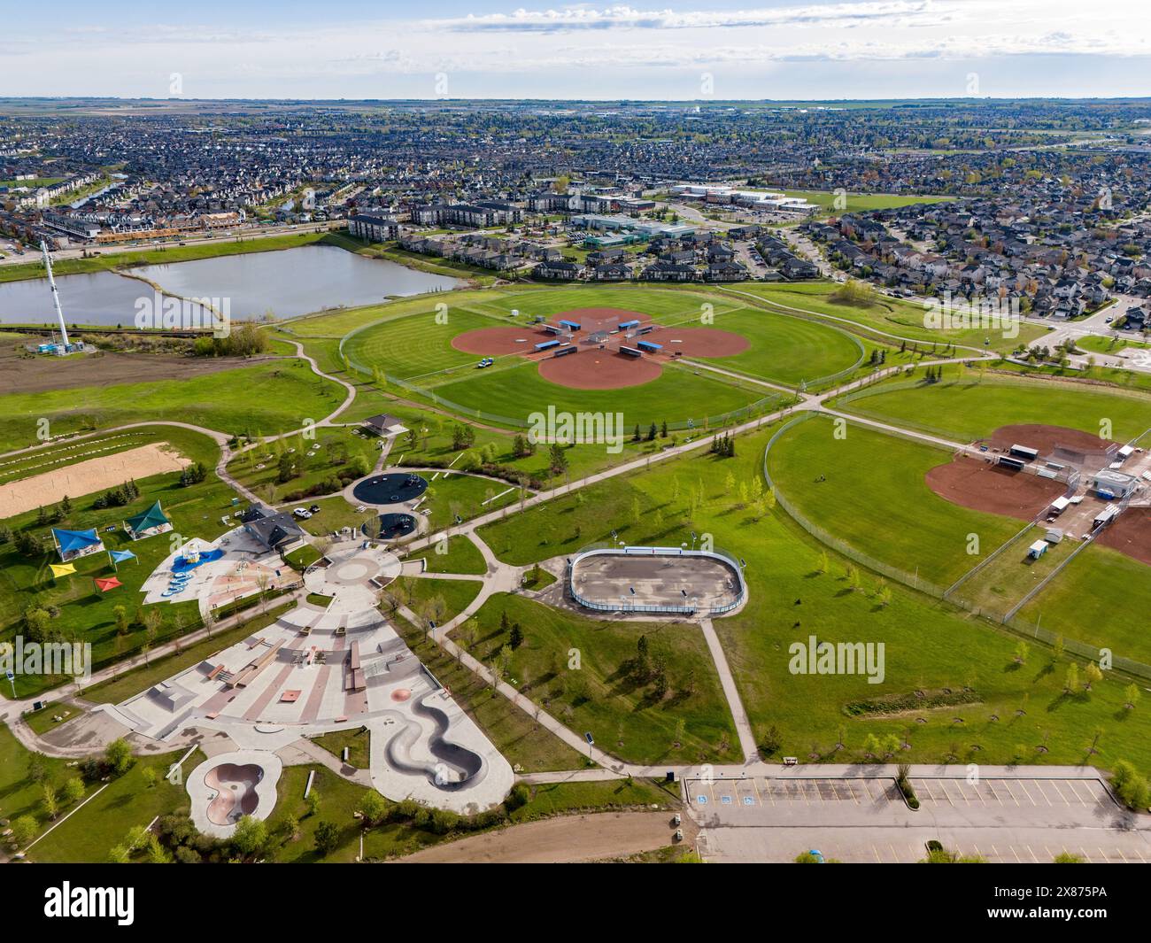 Airdrie Alberta Canada, May 21 2024: High aerial Chinook Winds Park overlooking baseball diamonds and distant storm water retention pond. Stock Photo