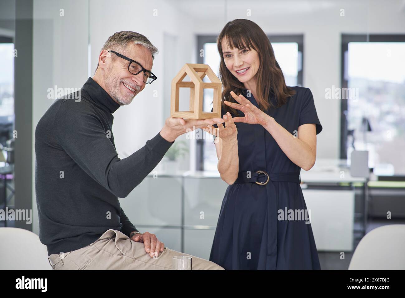 Two smiling architects examining model house in office Stock Photo