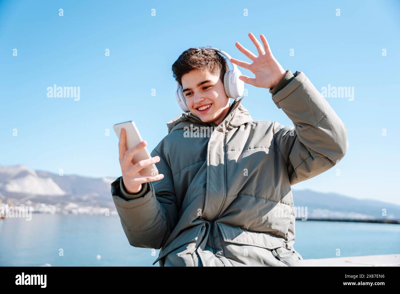 Happy boy waving on video call through smart phone Stock Photo - Alamy