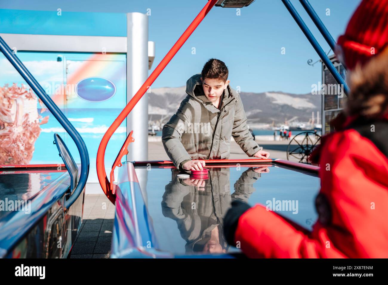 Boy competing with brother in air hockey Stock Photo