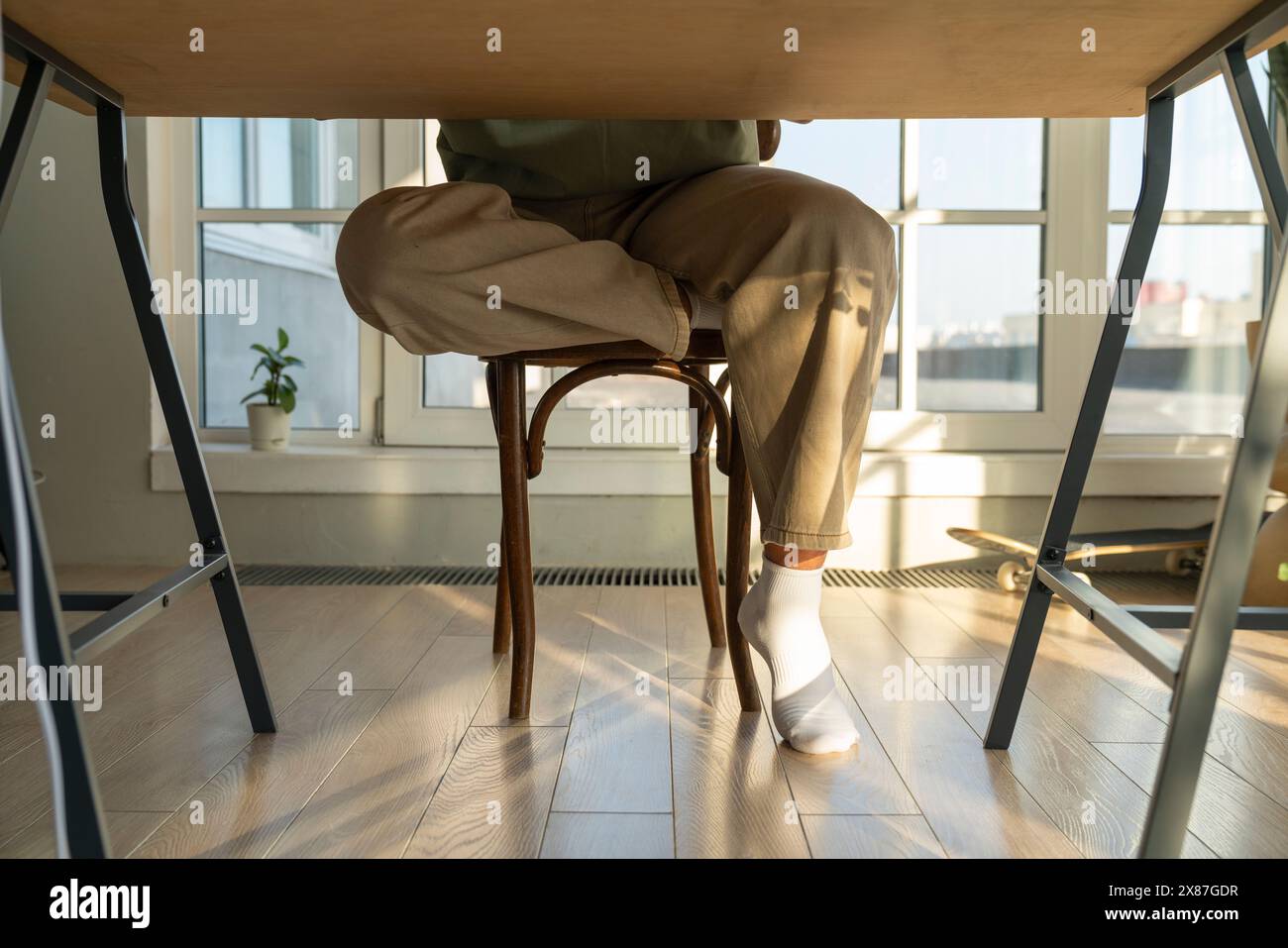 Man sitting on chair at table in home Stock Photo