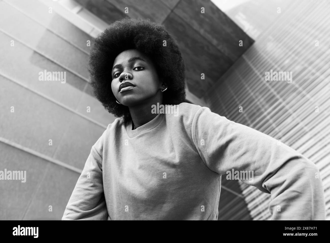 Confident young woman with Afro hairstyle near building Stock Photo