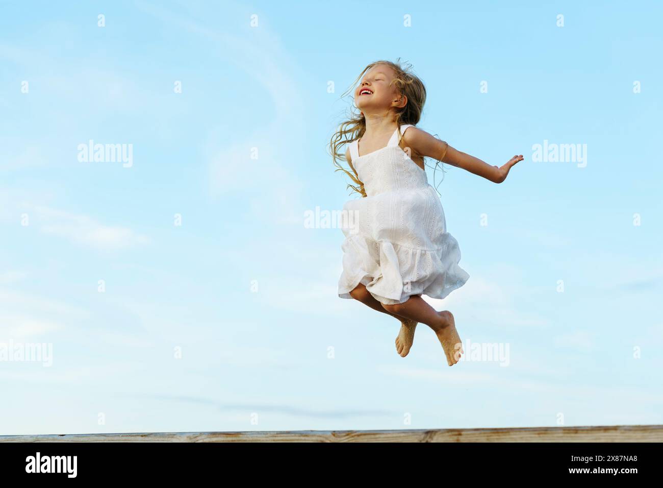 Children jumping blue sky hi-res stock photography and images - Alamy