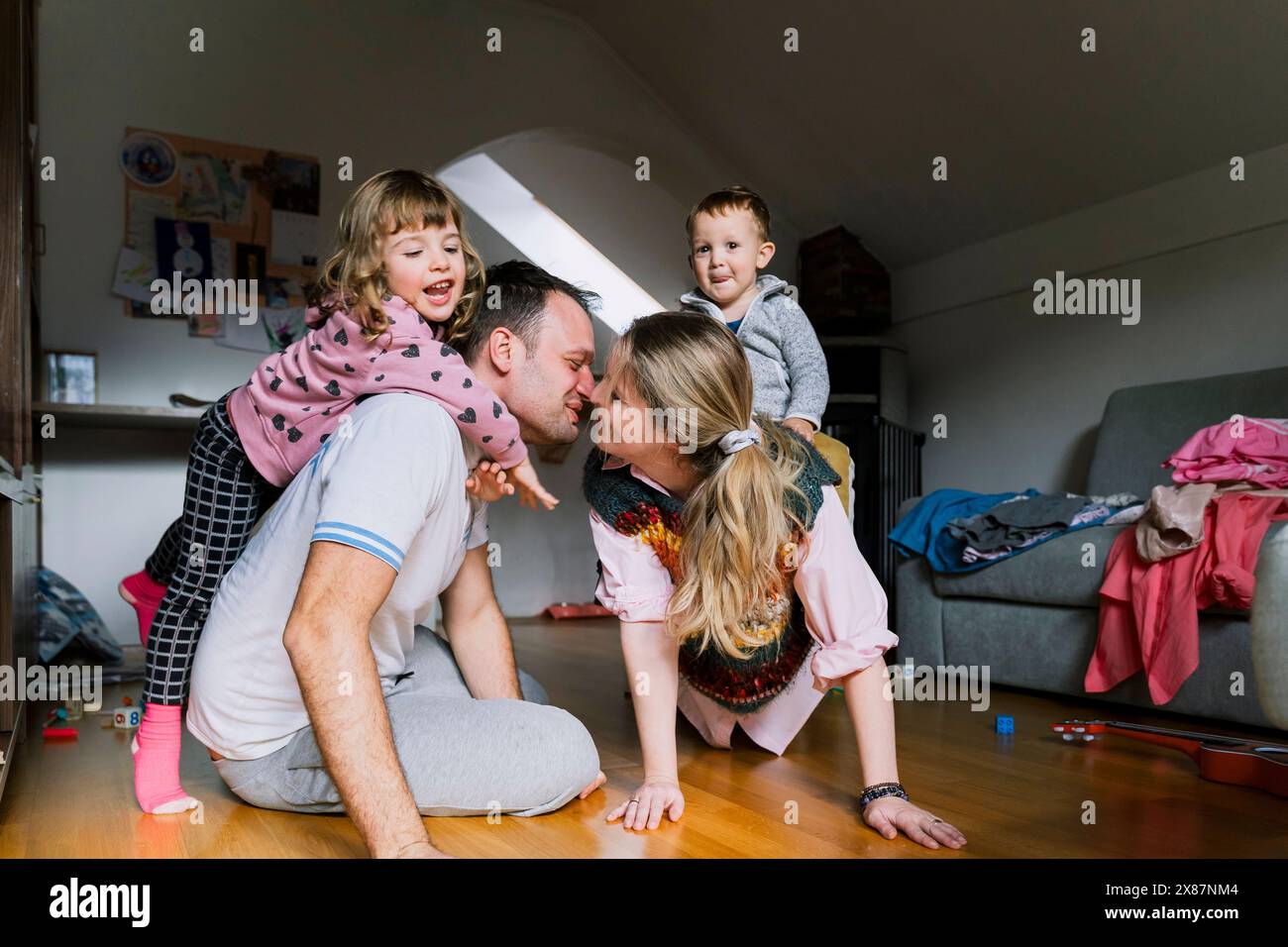 Parents with children playing in living room at home Stock Photo