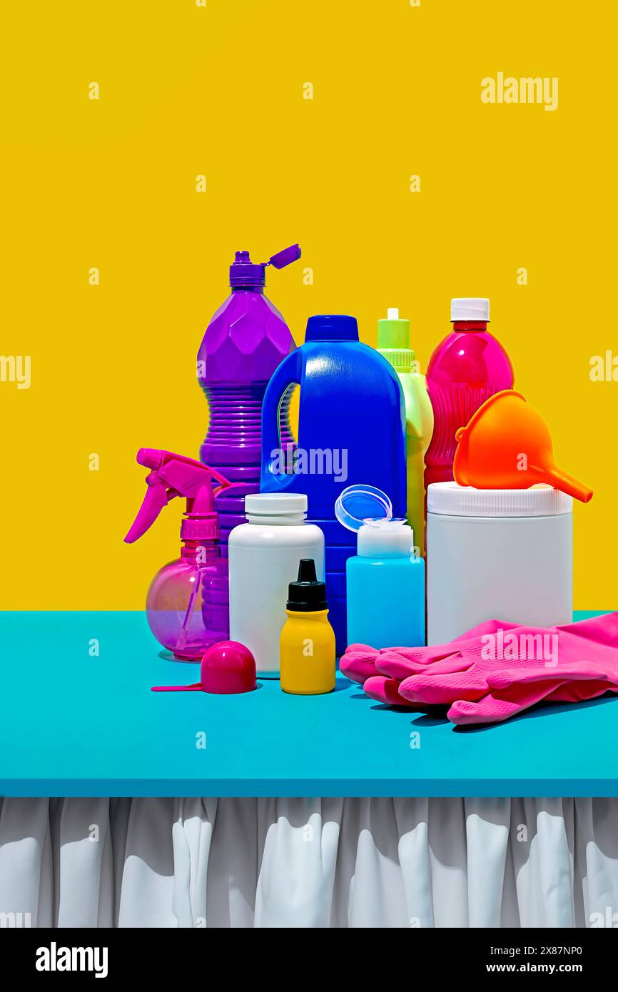 Still life of cleaning products on table against yellow background Stock Photo