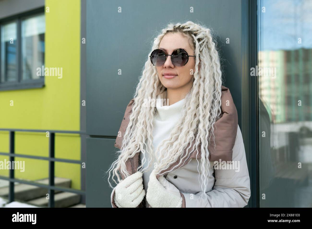 Woman With White Dreadlocks Leaning Against a Wall Stock Photo