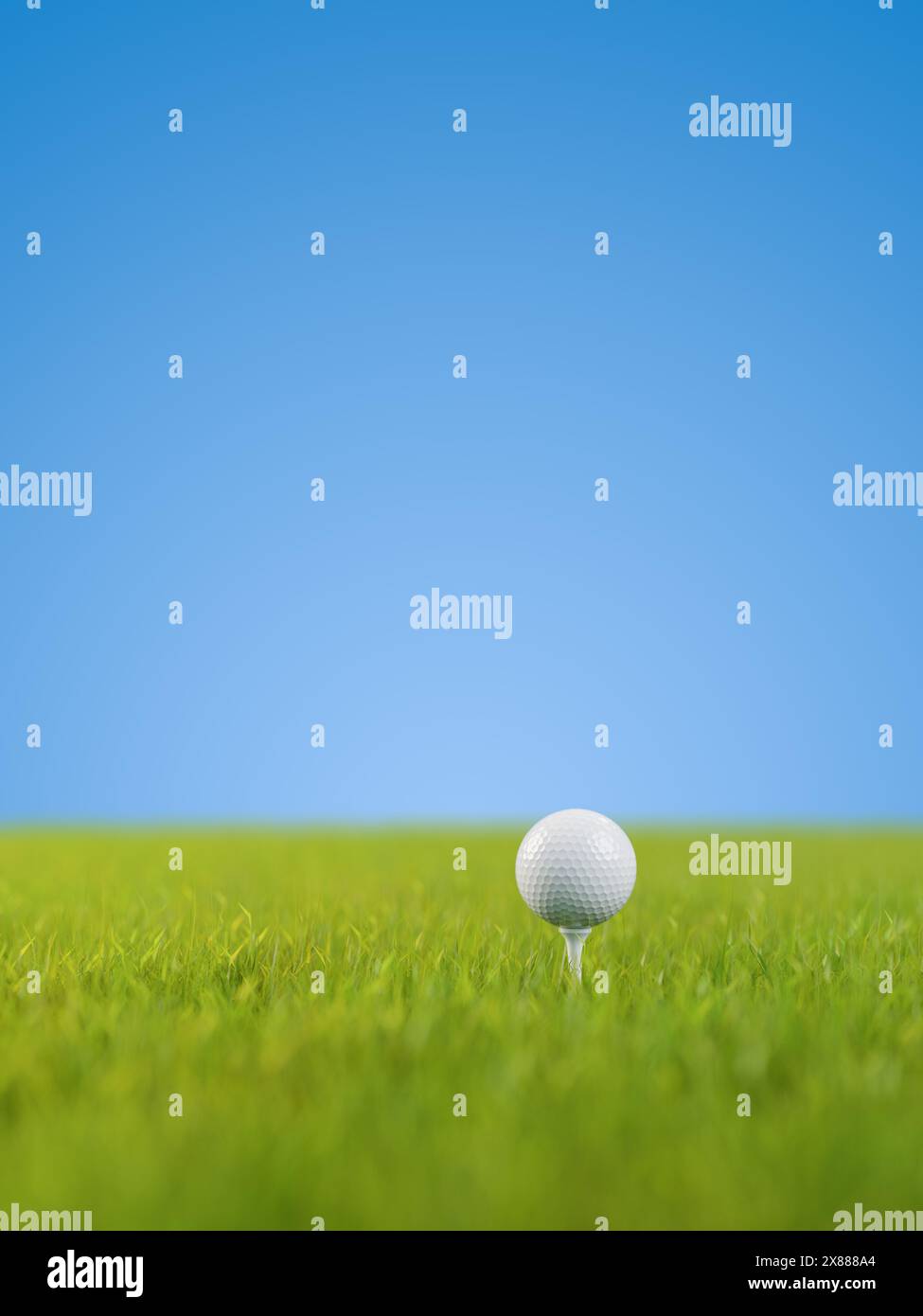 A golf ball on a golf tee on a lawn. Selective focus - very shallow depth of field. Blue background. Stock Photo